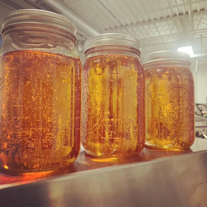 Jars of golden distillate - 100% purity. 